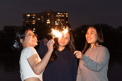 Three friends playing with the light sticks.